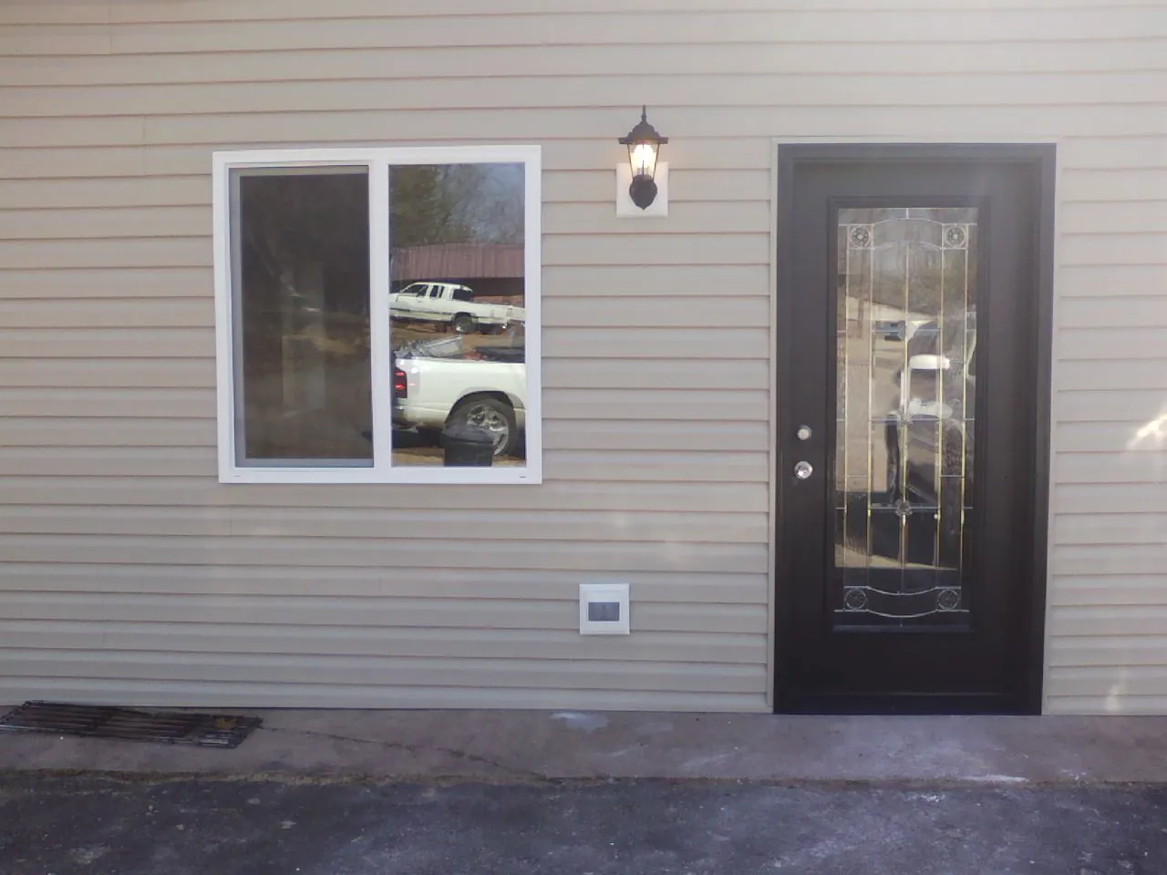 New siding, window and entry door on the side of an addition in Antwerp