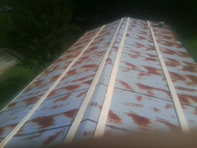 Rusted metal roof panels with new wood purlins before replacement — Storm Damage Roof Repair in Antwerp by Roofing Brothers