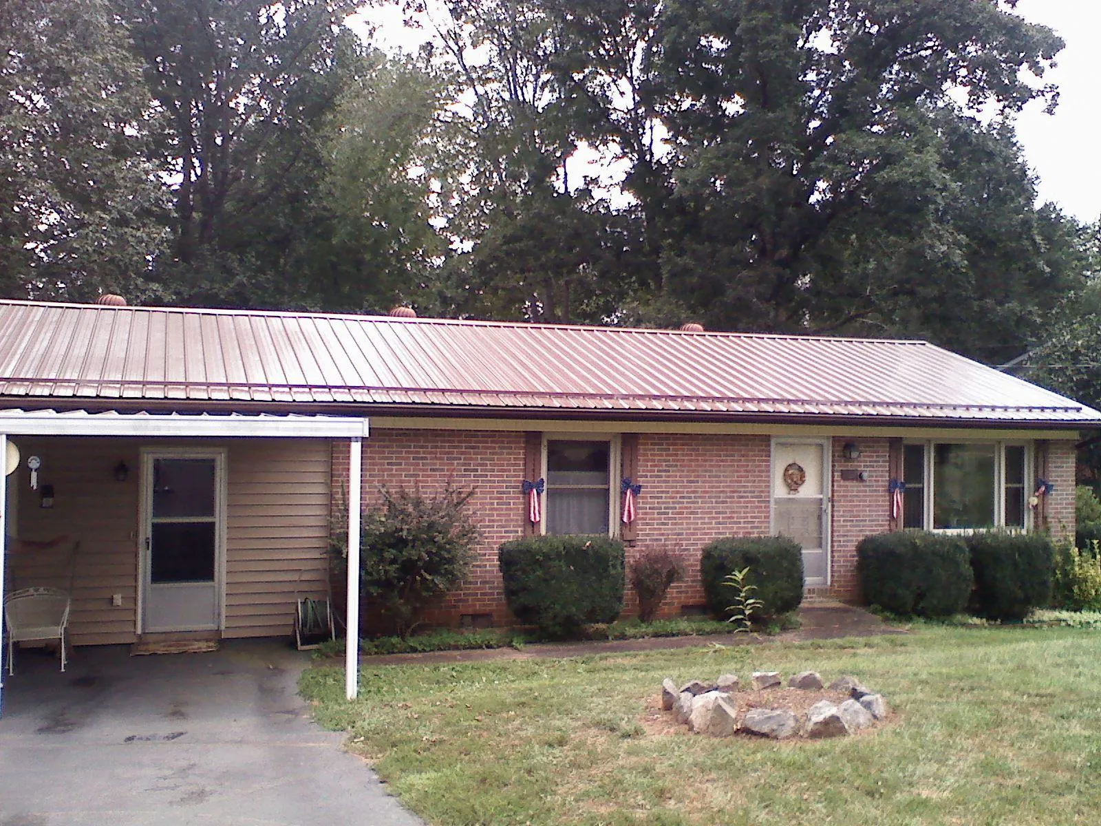 Bronze metal roof and carport on a brick ranch home — Roof Repair work by our crew in Antwerp